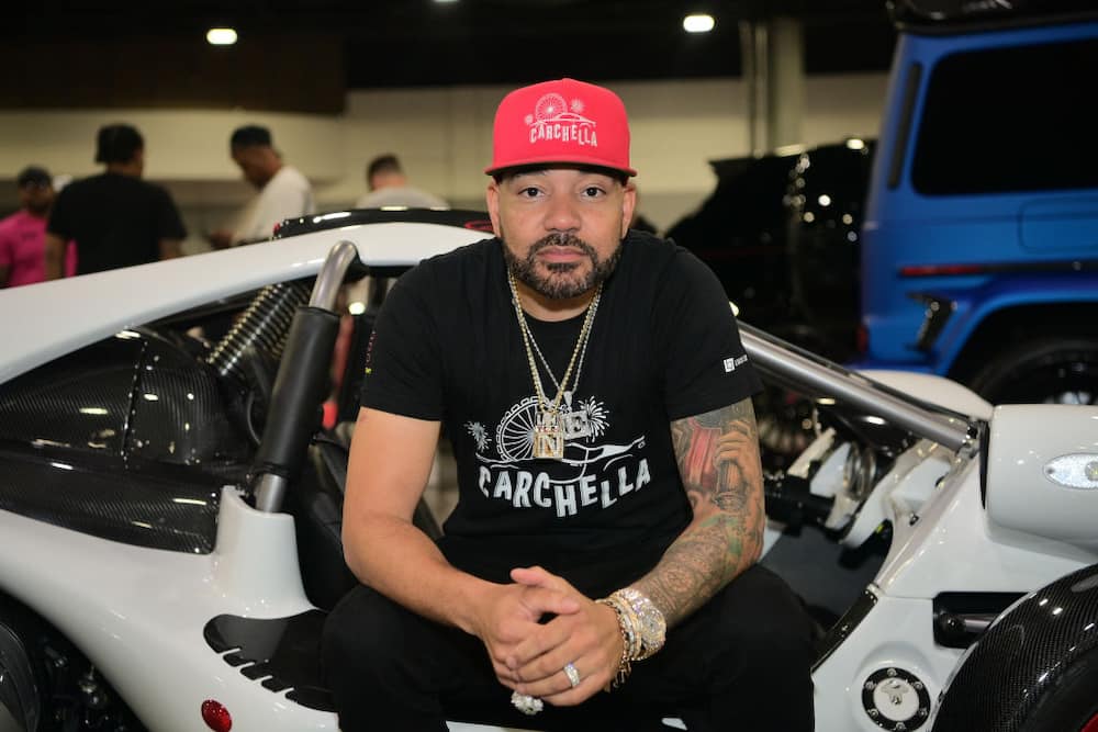 DJ Envy sitting on his white Lamborghini 