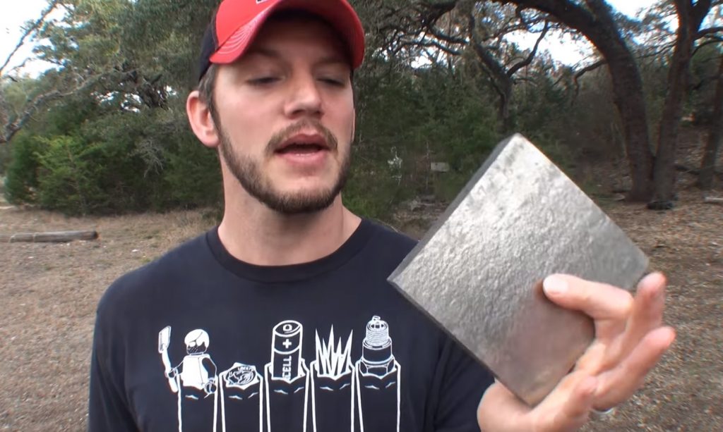 man holding a squared piece of titanium
