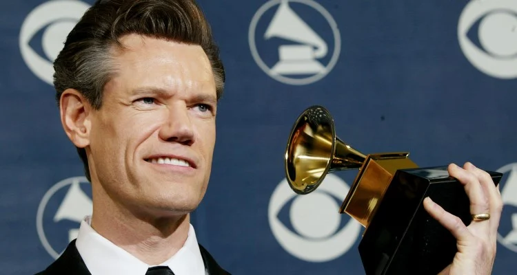 Randy Travis holding his award
