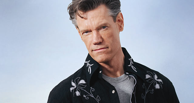 Randy Travis wearing a black jacket