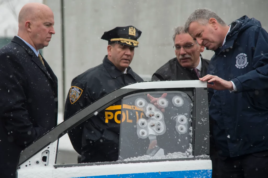 police officers holding a car door with holes of gunshot in the window