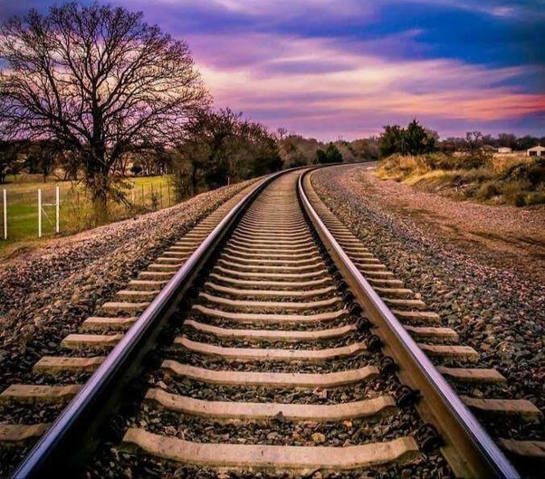 a rail way track with broken stones ballast