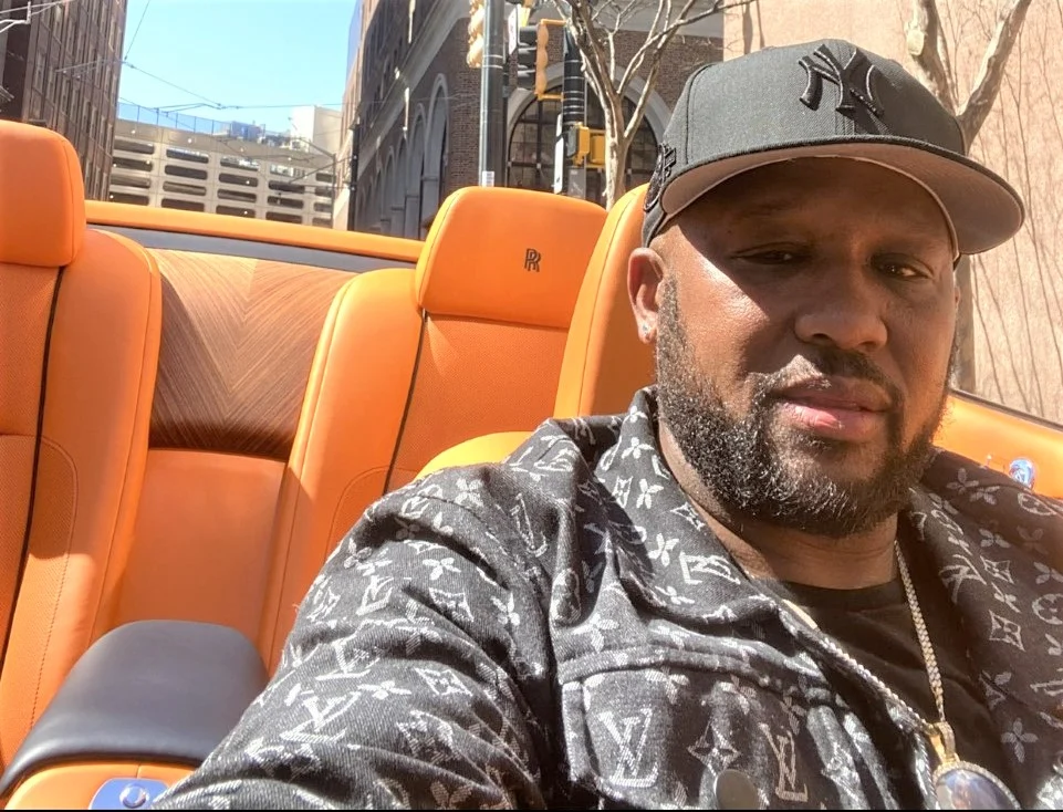 Alpo Martinez in his car wearing a cap
