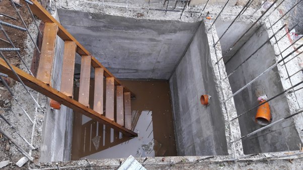 construction of a concrete septic tank on site with a ladder inside 