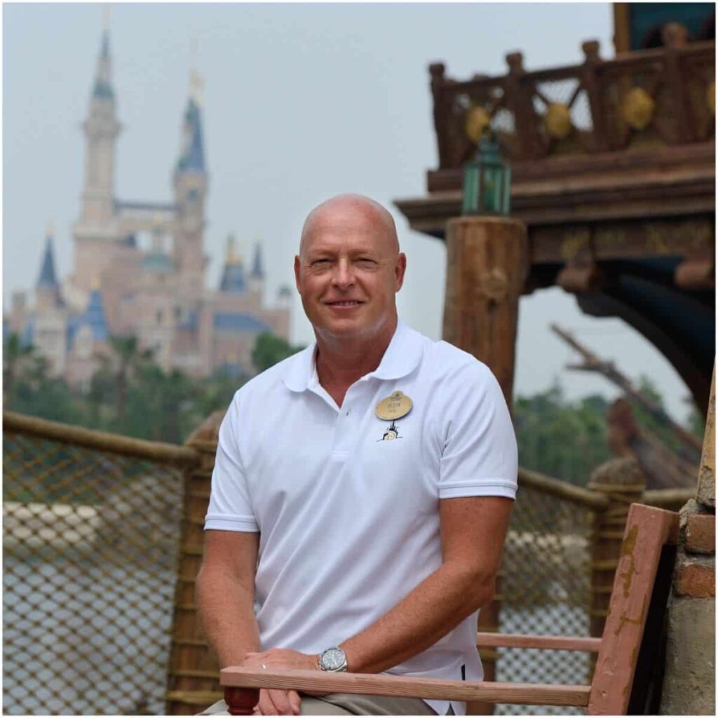 Bob Chapek wearing a white polo and sitting on a chair