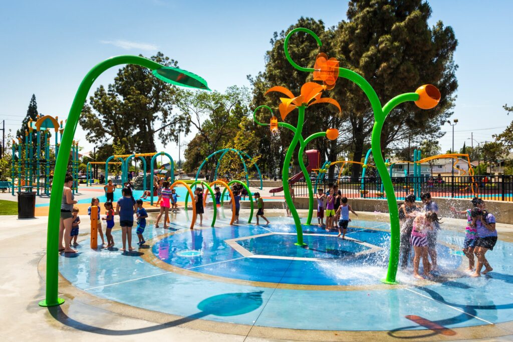 people playing around a water pool in a public park